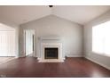 Bright living room featuring dark wood floors, a fireplace, and vaulted ceilings at 119 Lippizanner Pl, Zebulon, NC 27597