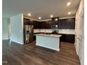 Modern kitchen boasts stainless steel appliances, granite countertops, dark cabinetry and a convenient kitchen island at 120 Anise Tree Way, Clayton, NC 27527