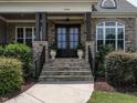 Close up of the elegant front door, showcasing stone accents and manicured landscaping at 1509 Yardley Dr, Wake Forest, NC 27587
