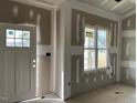 Unfinished living room with large window and door at 17 Golden View Pl, Zebulon, NC 27597