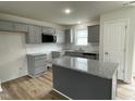 Modern kitchen with gray cabinets, granite countertops, and an island at 395 Magnolia Run Way, Benson, NC 27504