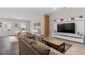 Open-concept living area with a sectional sofa, a large TV, and hardwood floors at 505 Great Eno Path, Hillsborough, NC 27278