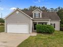 Exterior view of a home with gray siding, dark shutters, and an attached two-car garage with a paved driveway at 5110 Chipstone Dr, Raleigh, NC 27610