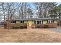 Charming single-story home with a brick foundation and a bright yellow front door at 5232 Guess Rd, Durham, NC 27712