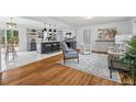Open concept living room featuring hardwood floors, modern lighting, and an eat-in kitchen at 5232 Guess Rd, Durham, NC 27712