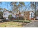 Beautiful home with brick accents, white siding, mature trees, and established landscaping at 5410 Thayer Dr, Raleigh, NC 27612
