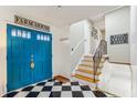 Welcoming foyer with black and white checkered floors, blue doors, and a staircase at 5410 Thayer Dr, Raleigh, NC 27612