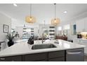 Modern kitchen with stainless appliances, a large island with sink, and stylish pendant lighting at 612 Sweet Pine Ln, Knightdale, NC 27545