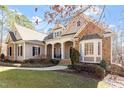 Beautiful single-Gathering home featuring stone accents, covered porch with stately columns, and lush landscaped yard at 10014 Hammock Bend Bnd, Chapel Hill, NC 27517