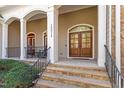 Inviting front porch featuring stone steps, decorative columns, and a double door entrance for a warm welcome at 10014 Hammock Bend Bnd, Chapel Hill, NC 27517