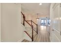 Bright entryway with wood staircase, light walls, and modern flooring leading to the open living space at 103 Hundred Oaks Ln, Holly Springs, NC 27540