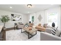 Bright living room featuring neutral furniture, large windows, and wood flooring at 106 N Trail Dr, Raleigh, NC 27615
