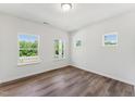 Bright bedroom featuring hardwood floors and three windows offering ample natural light at 110 Cribbs Ln, Middlesex, NC 27557