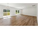 Spacious living room featuring hardwood floors, a modern light fixture, and outdoor access to the deck at 110 Cribbs Ln, Middlesex, NC 27557