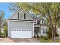 Charming two-story home featuring an attached two-car garage and a welcoming front porch at 1230 Auburn Village Drive Dr, Durham, NC 27713