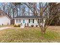 Quaint one-story home featuring a bright blue front door and black window shutters at 200 Westbury Dr, Oxford, NC 27565