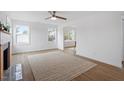 Bright living room featuring a large window, a ceiling fan, and a modern rug at 2001 Rolesville Rd, Wake Forest, NC 27587