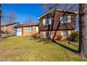 Two-story home with a brick and wood exterior, featuring a well-kept lawn and mature trees at 206 Eastway Ln, Graham, NC 27253