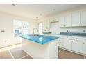 Modern kitchen with white cabinets, stainless steel sink and countertops covered in protective film during construction at 2481 Michelle Dr, Burlington, NC 27217