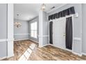 Inviting entryway featuring beautiful wood-look floors and a modern chandelier at 2506 Pepperstone Dr, Graham, NC 27253