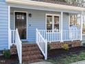 Inviting front porch with brick steps and a black front door at 2555 N Shiloh Rd, Garner, NC 27529