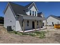 New construction home with a covered porch and gray siding under a blue sky at 3943 Baileys Xrds Rd, Benson, NC 27504