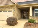 Close up of the home's stone facade, front porch, and a tidy landscape at 3947 Foxglove Trl, Burlington, NC 27215
