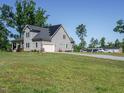 Sprawling property featuring an attached garage, additional parking and expansive lawn at 3958 Buckhorn Rd, Sanford, NC 27330