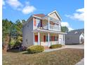 Side view of a two-story home with a front porch and a second-story balcony, surrounded by trees at 5841 Wynmore Rd, Raleigh, NC 27610