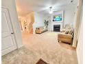 Bright living room with plush carpeting, fireplace, and comfortable seating arrangement at 5841 Wynmore Rd, Raleigh, NC 27610