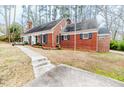 Side view of brick house showcasing the driveway, multiple windows, and classic architecture at 612 W Chisholm St, Sanford, NC 27330