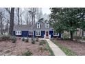 Classic blue home featuring a well-manicured lawn, walkway, and carefully selected shrubbery in a tranquil setting at 6317 Lakeland Dr, Raleigh, NC 27612