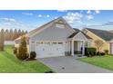 Beautiful one-story home with two-car garage, lush green grass and manicured shrubs at 65 Balsam Ln, Clayton, NC 27527