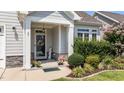 Charming front entrance with decorative door, stone accents, and inviting landscaping with flowering plants at 65 Balsam Ln, Clayton, NC 27527