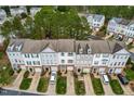 Aerial view of townhomes showcases the community's layout with individual driveways, green spaces, and mature trees at 707 Sutter Gate Ln, Morrisville, NC 27560