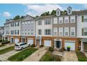 Charming townhomes featuring brick accents, varied siding, and attached garages, creating inviting curb appeal at 707 Sutter Gate Ln, Morrisville, NC 27560