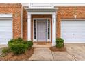 Inviting front entrance with brick facade, white trim, and landscaped bushes enhancing curb appeal at 707 Sutter Gate Ln, Morrisville, NC 27560