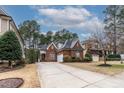 A classic brick home is surrounded by green trees and a long driveway at 7373 Newport Ave, Raleigh, NC 27613