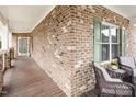 Relaxing porch with brick walls, ample seating, and a green front door at 812 Canyoncreek Ln, Fuquay Varina, NC 27526