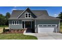 Inviting two-story home with a gray roof, attached garage, manicured lawn, and lovely landscaping at 83 Nottoway Lane, Wendell, NC 27591