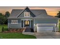 Well-manicured lawn and light green siding accent the charming home with its brick stairs and attached garage at 83 Nottoway Lane, Wendell, NC 27591