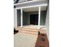 The house has a beautiful front door with brick steps and white columns for a welcoming entrance at 83 Nottoway Lane, Wendell, NC 27591