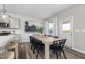 Open dining area with a rustic wooden table, black chairs, and modern decor at 1004 Freestone Rd, Durham, NC 27703
