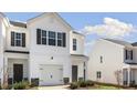 Two story townhome with a one car garage, dark shutters, and lawn at 204 Starlight St, Sanford, NC 27330