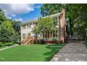 Charming two-story home features lush green lawn, mature trees, and brick chimney at 207 Wyatts Pond Ln, Cary, NC 27513