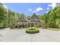 Beautiful brick home featuring manicured landscaping, a circular driveway, and classic architectural details at 209 Democracy Pl, Apex, NC 27523