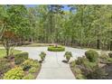 Well-maintained front yard showcasing lush greenery, a circular driveway, and beautiful landscaping details at 209 Democracy Pl, Apex, NC 27523