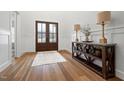 Bright foyer with wood floors, paneled walls, wooden double doors and an elegant console table at 227 Beech Slope Ct, Chapel Hill, NC 27517