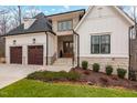 Striking two-story home with a stone and white exterior, showcasing a well-kept lawn and a spacious driveway at 227 Beech Slope Ct, Chapel Hill, NC 27517