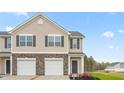 Beautiful townhome showcasing the detailed stone accents, gray door, and newly landscaped yard at 268 Moyer Dr, Graham, NC 27253